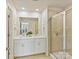 Well-lit bathroom featuring dual sinks, a shower with a glass enclosure, and modern fixtures throughout at 2610 Greenmarket Dr, Charlotte, NC 28217