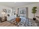 Cozy living room features neutral tones, abstract art, a sliding glass door, and a patterned rug at 2610 Greenmarket Dr, Charlotte, NC 28217