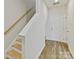 Interior staircase is highlighted by sleek handrails, light wood treads, and neutral walls for a modern design aesthetic at 2610 Greenmarket Dr, Charlotte, NC 28217