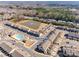 Panoramic aerial view of community with townhomes surrounding a pond with fountain and wooded area at 2635 Winter Thistle Way, Indian Land, SC 29707