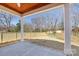 Covered backyard patio with concrete flooring overlooking a newly fenced in spacious yard at 302 Lincoln St, Belmont, NC 28012