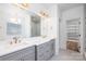 Bathroom featuring double sinks, gray cabinets with gold hardware, and a separate shower and closet area at 302 Lincoln St, Belmont, NC 28012