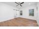 Spacious bedroom with hardwood floors, two windows, and a barn door leading to the bathroom at 302 Lincoln St, Belmont, NC 28012