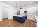 Well-lit kitchen with white cabinets, stainless steel appliances, a blue island, and hardwood floors at 302 Lincoln St, Belmont, NC 28012