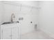 Functional laundry room with stainless steel sink, white cabinetry, and tile floor, offering convenience and style at 302 Lincoln St, Belmont, NC 28012