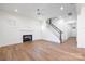 Open-concept living room with a fireplace, hardwood floors, and a staircase leading to the upper level at 302 Lincoln St, Belmont, NC 28012