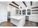 Modern kitchen with an island, stainless steel appliances, white cabinets, and wood beam accents at 3115 Pinehurst Pl, Charlotte, NC 28209