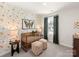 Bedroom with butterfly wallpaper, a wooden crib, ottomans, side table, and dark-colored curtains at 313 Alden Ct, Shelby, NC 28152