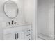 Modern bathroom with a sleek white vanity, a round mirror, and a glass-enclosed shower featuring subway tiles at 3732 Whitney Ne Dr, Hickory, NC 28601