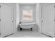 Bright bathroom showcasing a standalone tub with black hardware between two doors, creating a private and luxurious retreat at 3732 Whitney Ne Dr, Hickory, NC 28601