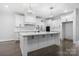 Elegant white kitchen featuring a large center island, modern pendant lights, and stainless appliances at 3732 Whitney Ne Dr, Hickory, NC 28601