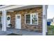 Close-up of a charming stone porch with a white door and window at 3931 Newhall Nw Dr, Hickory, NC 28601