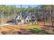 Stunning exterior of a light and stone home nestled among the trees with a manicured lawn at 4354 Persimmon Rd, Lancaster, SC 29720