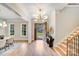 Bright foyer featuring an open door, hardwood floors, statement lighting, and a staircase with wood and black metal accents at 4354 Persimmon Rd, Lancaster, SC 29720