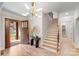 Bright foyer featuring an open door, hardwood floors, statement lighting, a staircase, and decorative accents at 4354 Persimmon Rd, Lancaster, SC 29720