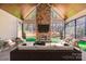 Inviting living room featuring a stone fireplace and floor-to-ceiling windows with picturesque views of the surrounding forest at 4354 Persimmon Rd, Lancaster, SC 29720