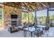 Outdoor patio area with stone fireplace, comfortable seating, and dining tables, perfect for entertaining at 4354 Persimmon Rd, Lancaster, SC 29720