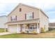 Well-maintained two-story house showcasing a manicured lawn, front porch, and an attached two car garage at 552 Montgomery Dr, Rock Hill, SC 29732