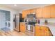 Bright kitchen equipped with stainless steel appliances, light wood cabinets, and a view of the laundry area at 552 Montgomery Dr, Rock Hill, SC 29732