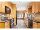 Kitchen featuring stone flooring, sleek black appliances, tile backsplash, and natural wood cabinets at 609 2Nd Ne St, Hickory, NC 28601