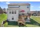 Back exterior view of the house with a deck, stairs, and lawn at 7217 Kenyon Dr, Denver, NC 28037