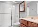 Well-lit bathroom with a white tile shower, vanity with modern faucet, and cherry wood cabinetry at 7217 Kenyon Dr, Denver, NC 28037