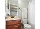Bright bathroom featuring granite vanity, wood cabinetry, toilet and tiled shower and bathtub at 7217 Kenyon Dr, Denver, NC 28037