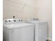 Functional laundry area equipped with modern washing machine and dryer, plus overhead wire shelving at 7217 Kenyon Dr, Denver, NC 28037