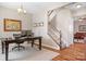 Home office features a dark wood desk, computer, and a view of the carpeted staircase at 7217 Kenyon Dr, Denver, NC 28037