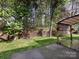 Landscaped backyard featuring a covered patio, lawn, privacy fence, and mature trees at 8830 Beaver Creek Dr, Charlotte, NC 28269