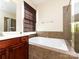 Bathroom showcasing a soaking tub, glass-enclosed shower, and a single vanity at 8830 Beaver Creek Dr, Charlotte, NC 28269