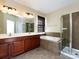 Bathroom featuring a double vanity, soaking tub, and glass-enclosed shower at 8830 Beaver Creek Dr, Charlotte, NC 28269
