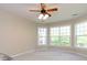 Bright, carpeted bedroom with a ceiling fan, light fixture, and many windows overlooking a scenic view at 8830 Beaver Creek Dr, Charlotte, NC 28269