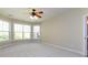 Bright, carpeted bedroom featuring large windows with a ceiling fan and light fixture at 8830 Beaver Creek Dr, Charlotte, NC 28269