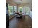 Bright dining area featuring a wooden table, four chairs, and multiple windows at 8830 Beaver Creek Dr, Charlotte, NC 28269