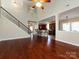 Open-concept living room with hardwood floors and staircase leading to kitchen with breakfast bar at 8830 Beaver Creek Dr, Charlotte, NC 28269