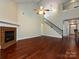 Bright living room featuring hardwood floors, a fireplace, and stairs leading to the second level at 8830 Beaver Creek Dr, Charlotte, NC 28269
