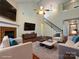 Bright living room with hardwood floors, a fireplace, and comfortable seating beneath a vaulted ceiling at 8830 Beaver Creek Dr, Charlotte, NC 28269