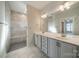 Modern bathroom featuring a double sink vanity, a walk-in shower, and neutral tile at 1005 Headwaters Ct, Matthews, NC 28104