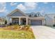 Charming single-Gathering home with stone accents, a covered porch, and a two-car garage at 1005 Headwaters Ct, Matthews, NC 28104