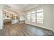 Open concept living room with wood floors, large windows and an island kitchen at 1005 Headwaters Ct, Matthews, NC 28104