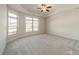 Main bedroom with lots of natural light, tray ceiling, and carpeted floors at 1005 Headwaters Ct, Matthews, NC 28104