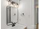Close-up of bathroom vanity featuring modern faucet, lighting, and mirror at 108 Colville Rd # 21B, Charlotte, NC 28207
