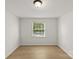 A bright bedroom with a window and wood-look flooring and neutral walls at 108 Colville Rd # 21B, Charlotte, NC 28207
