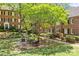 Brick buildings overlooking a verdant courtyard with patio dining set and grill, creating a peaceful outdoor space at 108 Colville Rd # 21B, Charlotte, NC 28207