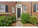 Close-up of the front door with decorative trim and manicured bushes at 108 Colville Rd # 21B, Charlotte, NC 28207