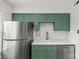 Well-lit kitchen with green cabinets, stainless steel fridge, and a modern sink at 108 Colville Rd # 21B, Charlotte, NC 28207