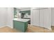 Kitchen area features green cabinetry, a white island, and stainless steel appliances at 108 Colville Rd # 21B, Charlotte, NC 28207