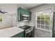 Stylish kitchen featuring green cabinets, stainless steel microwave, and modern appliances at 108 Colville Rd # 21B, Charlotte, NC 28207