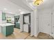Bright kitchen featuring green cabinetry, a white island, and a laundry closet at 108 Colville Rd # 21B, Charlotte, NC 28207